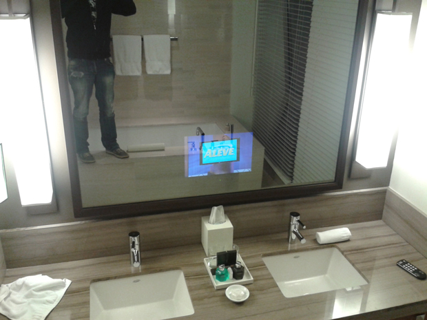 Tinha banheira e tinha TV atrás do espelho (que mente é essa que acha isso uma boa ideia?)