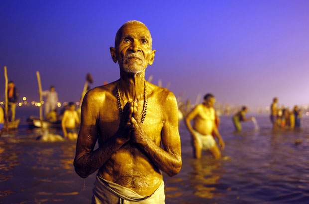 Um hindu devoto ora depois de um mergulho sagrado no Sangam, na confluência de três rios sagrados - o Ganges, o Yamuna e Saraswati mítico - durante o festival Kumbh Mela em Allahabad, na Índia